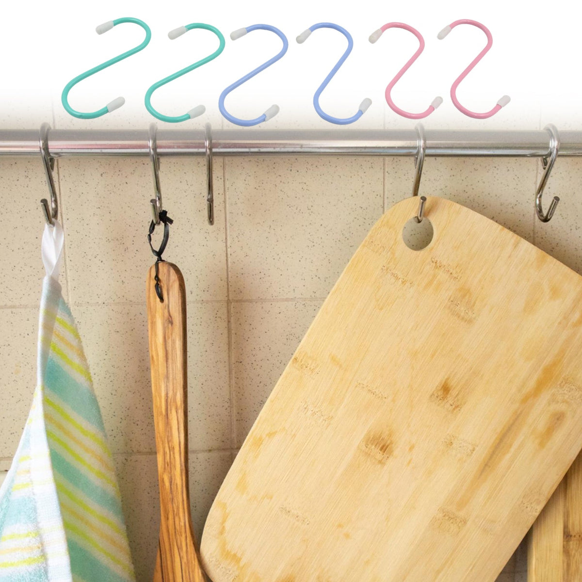 Six colorful plastic coated S hooks hanging on a metal rod above kitchen items like a towel and cutting boards.