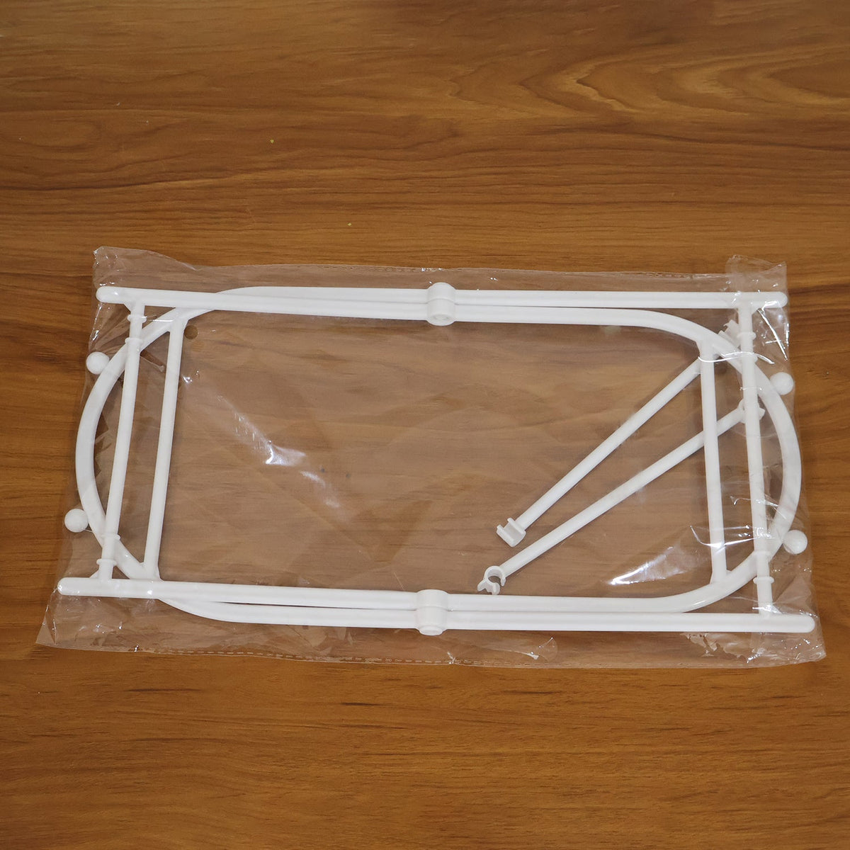 White plastic garbage bag holder components, disassembled and sealed in a clear plastic bag.