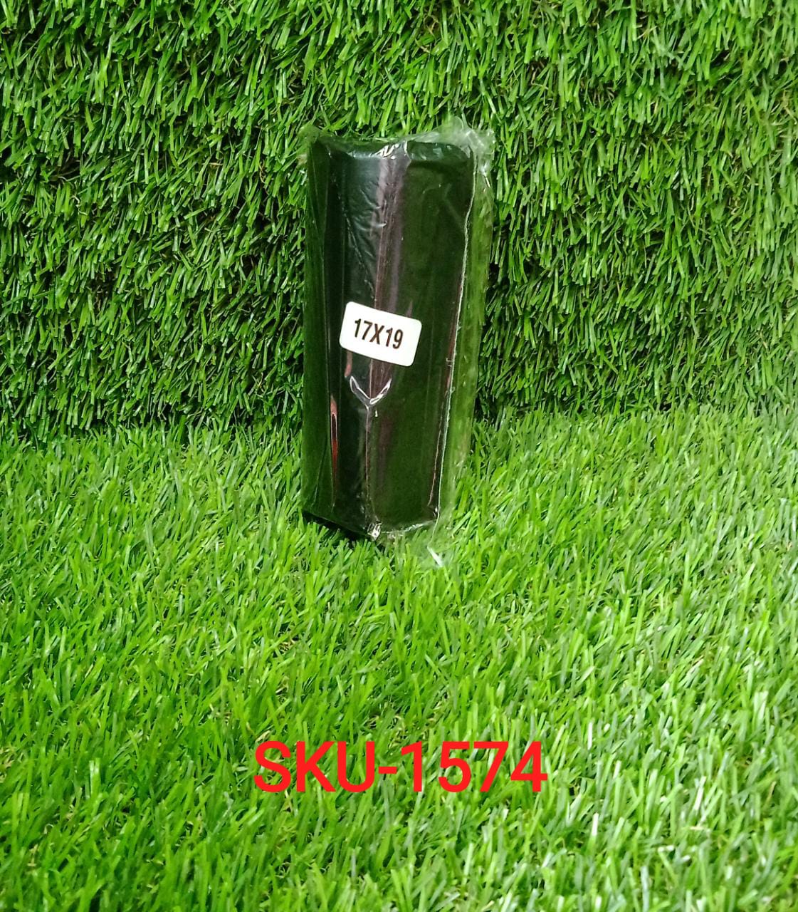 A single roll of black garbage bags with a '17X19' label, sitting on artificial green grass.