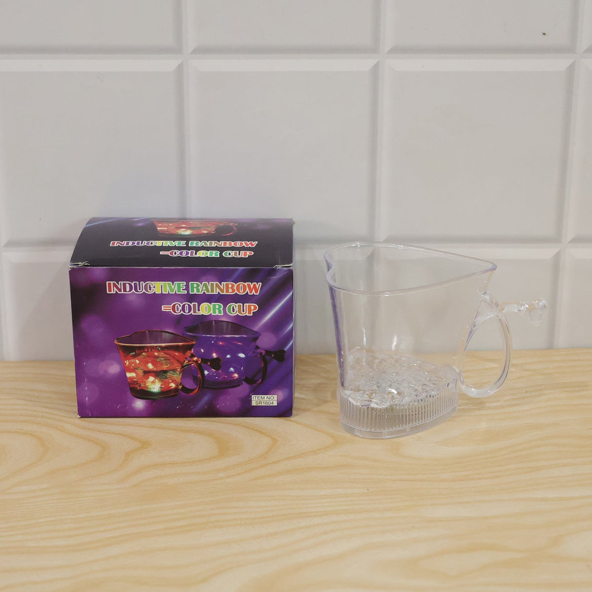 A clear heart-shaped mug sits next to its purple box, which features images of the glowing cups.