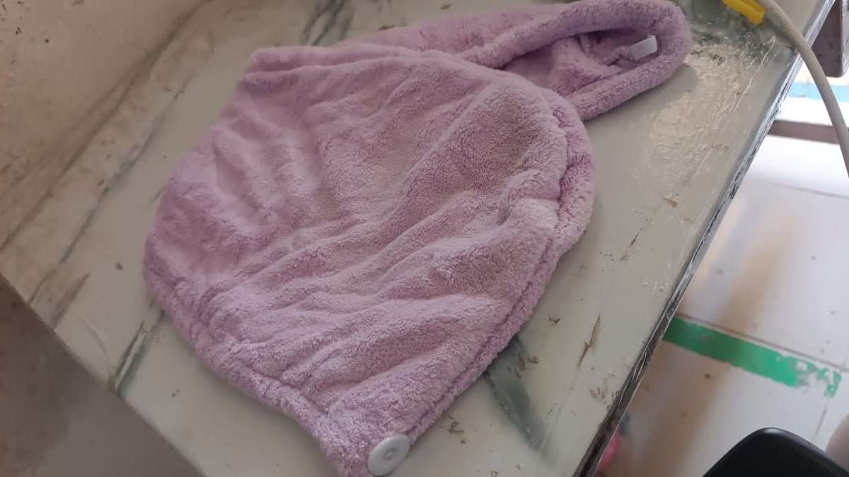 Lifestyle image of a woman comfortably wearing a microfiber hair drying wrap towel.