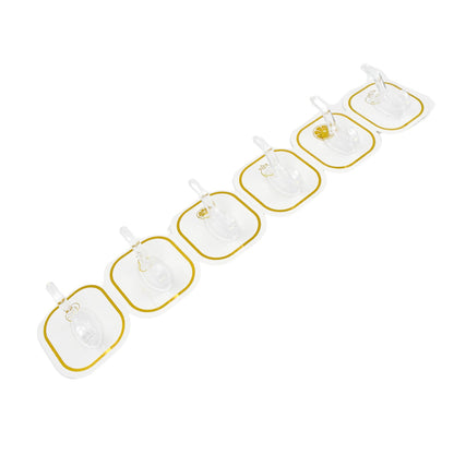 Six transparent adhesive hooks with gold borders arranged diagonally on a white background.