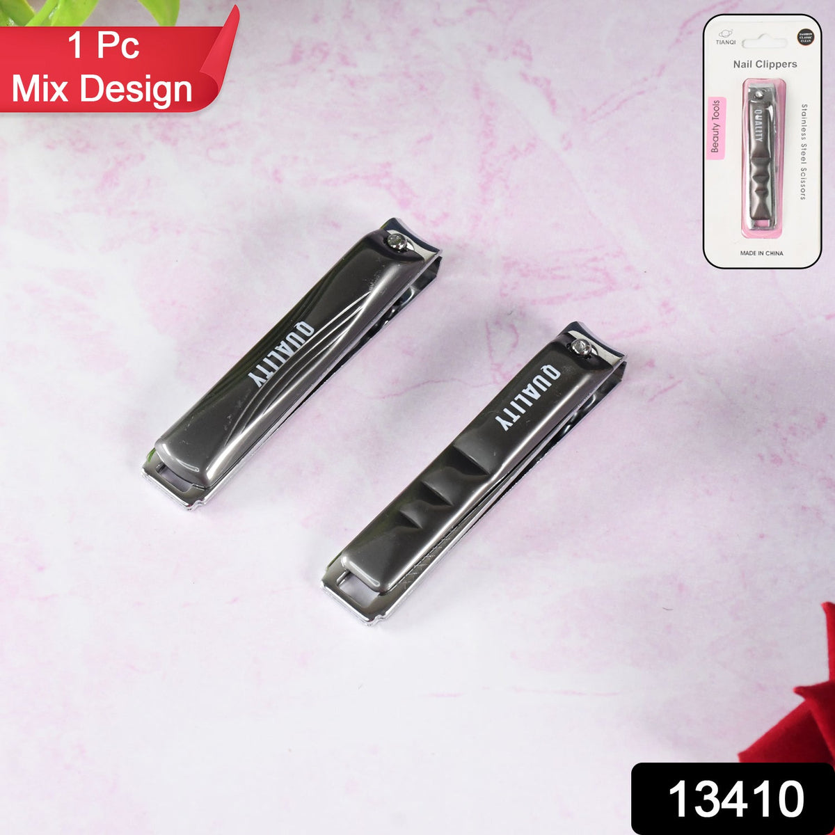 Two black and silver nail clippers on a pink marble surface, with packaging for one in the top right.