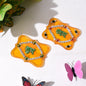 Two ornate yellow Shubh Labh wall hangings with green text and clear and colored jewels.