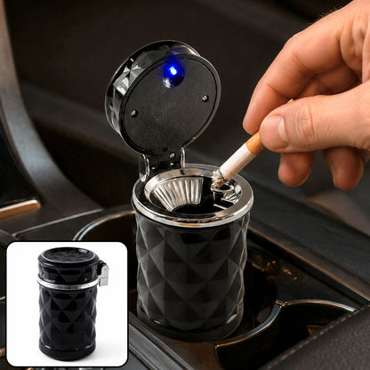A hand places a lit cigarette into a black car cup holder ashtray with a blue LED light.