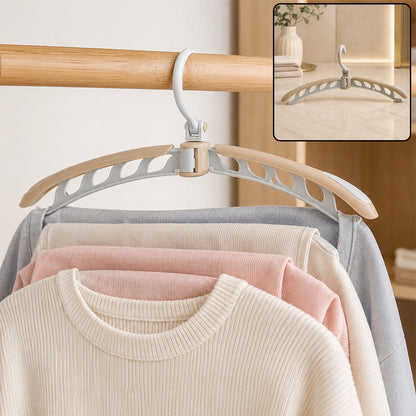 A beige and white folding hanger holding a cream sweater and light colored pants on a wooden rail. Inset shows the hanger