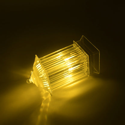 A single LED crystal lantern lamp lies on its side, casting a warm yellow glow on a dark, reflective surface.