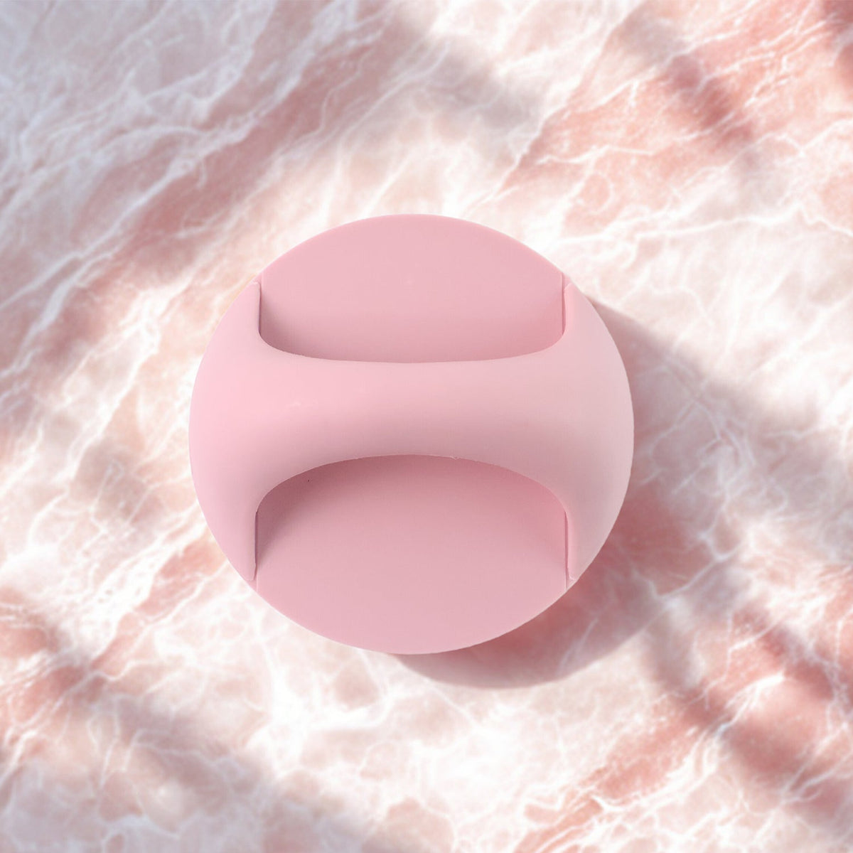 A pink self-adhesive handle is centered on a light pink marble background with soft shadows.