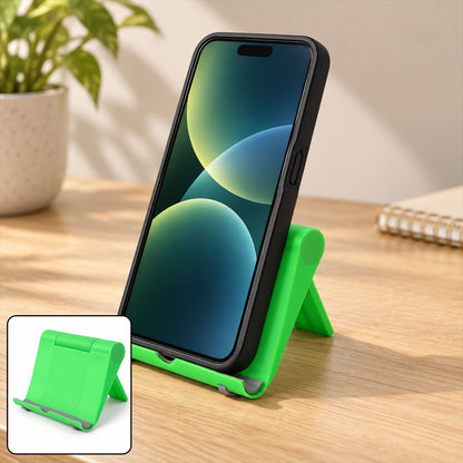 A black smartphone rests vertically on a bright green foldable stand on a wooden desk with a plant.