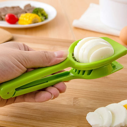 A hand holds a green plastic slicer, cutting a hard-boiled egg into uniform slices on a wooden cutting board.