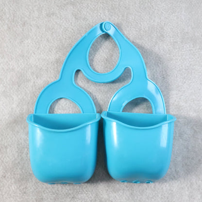 Front view of the blue plastic sink caddy with two compartments on a textured gray background.