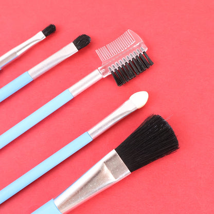 A close-up of five light blue makeup brushes with silver ferrules and black bristles, on a red background.