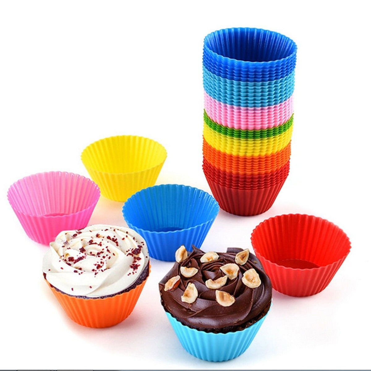 A stack of rainbow-colored silicone cupcake molds stands next to individual molds and two decorated cupcakes.
