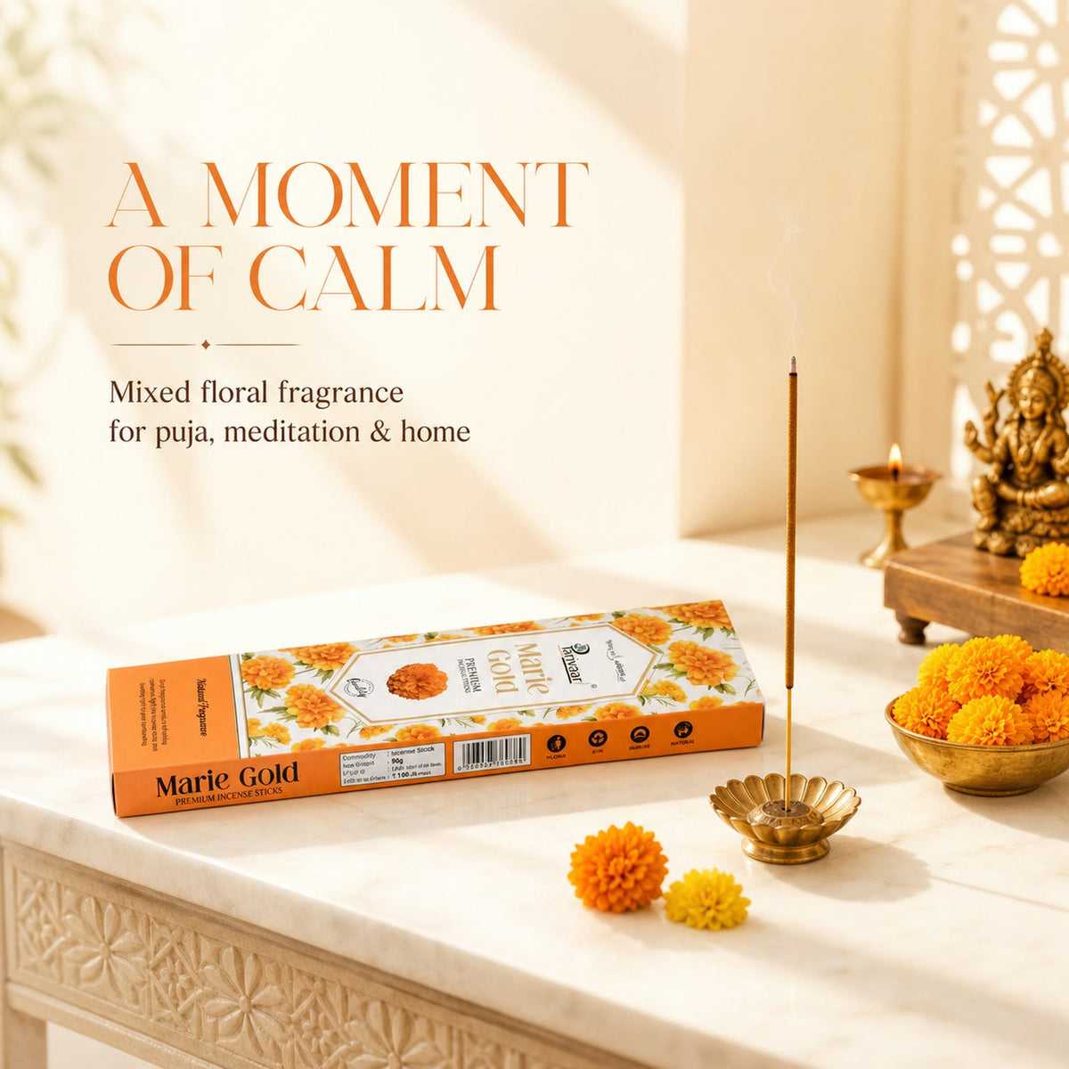 A single smoking brown incense stick in a gold holder next to an open orange box of Marie Gold incense.