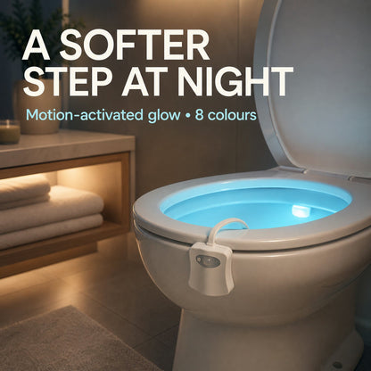 Toilet with a blue glowing bowl from the motion sensor light, in a softly lit bathroom setting with towels.