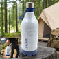 White and blue insulated water bottle with a handle on a rock, with a tent and forest in the background.