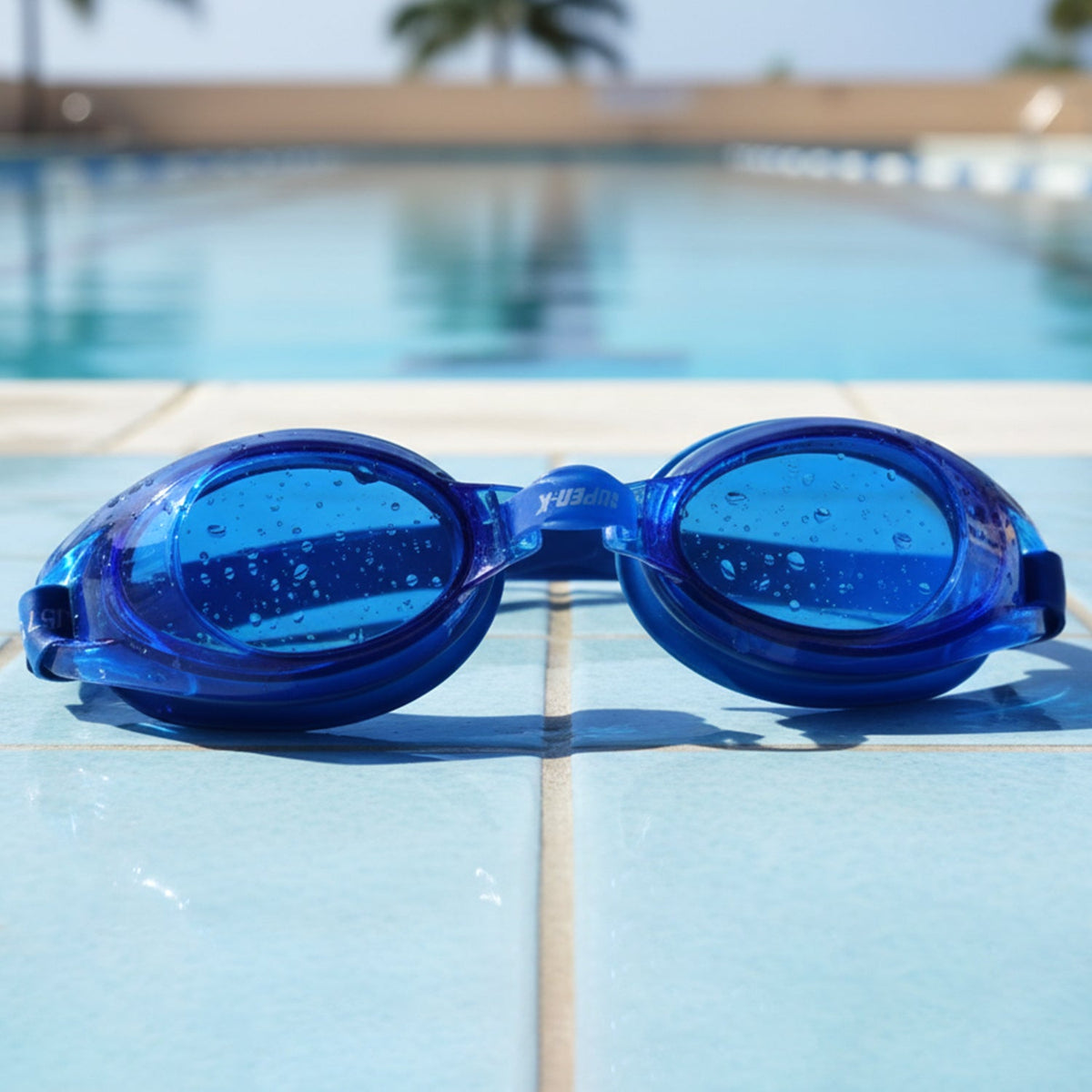 A two-piece set of swimming goggles, one black and one blue, sealed in clear plastic packaging with a blue and white backing