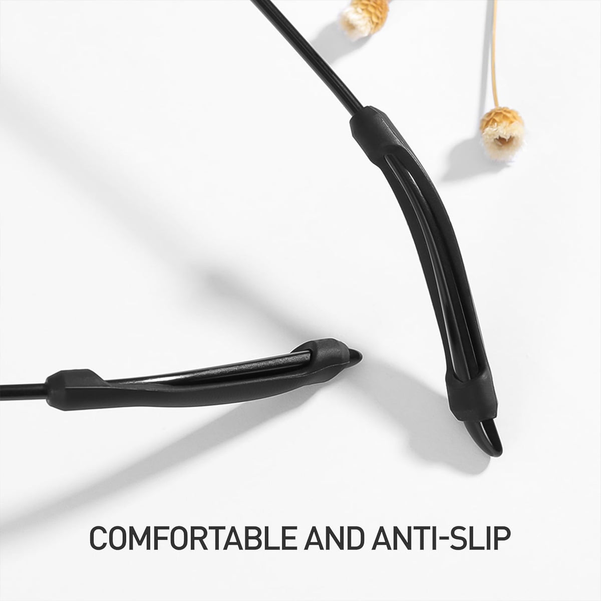 Close-up of two black anti-slip eyeglass ear grips on a white surface, with text "COMFORTABLE AND ANTI-SLIP".