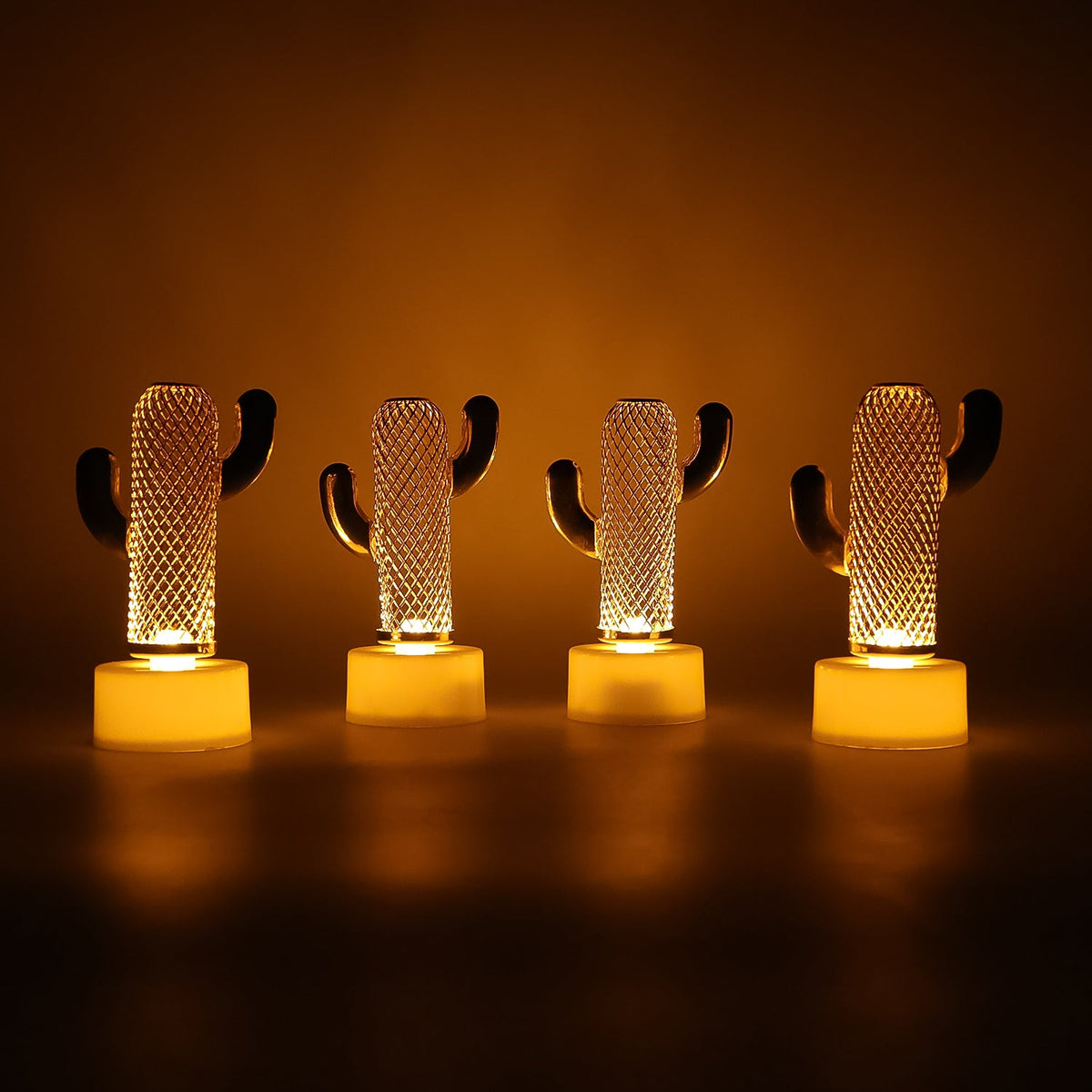 Four glowing cactus-shaped LED lights stand in a row on a dark surface, casting a warm orange glow.