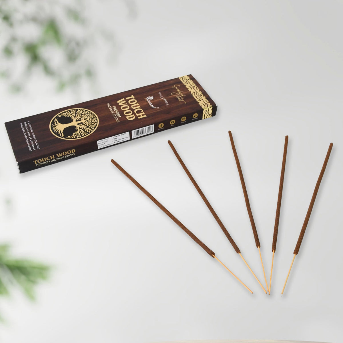 Five brown incense sticks fanned out in front of a dark brown box with a tree of life logo.