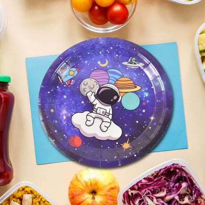 A single purple paper plate with an astronaut and planets design, placed on a blue napkin with food items.