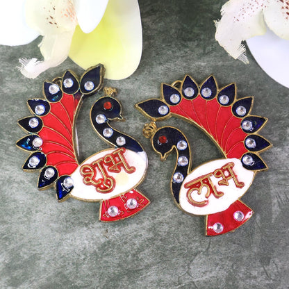 Two colorful peacock-shaped Shubh Labh wall hangings with red, blue, and white enamel, adorned with clear rhinestones.