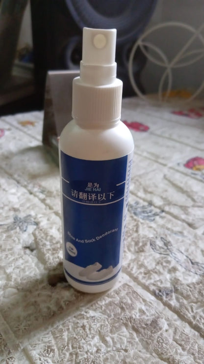 A white bottle with a blue label for shoe and sock deodorant stands on a patterned surface.