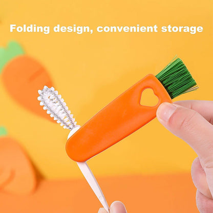 A hand holds the orange 3-in-1 cleaning brush, showing its folding design, against an orange background with carrot shapes.