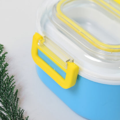 A close-up view of the yellow clasp on the side of the blue and white lunch box.
