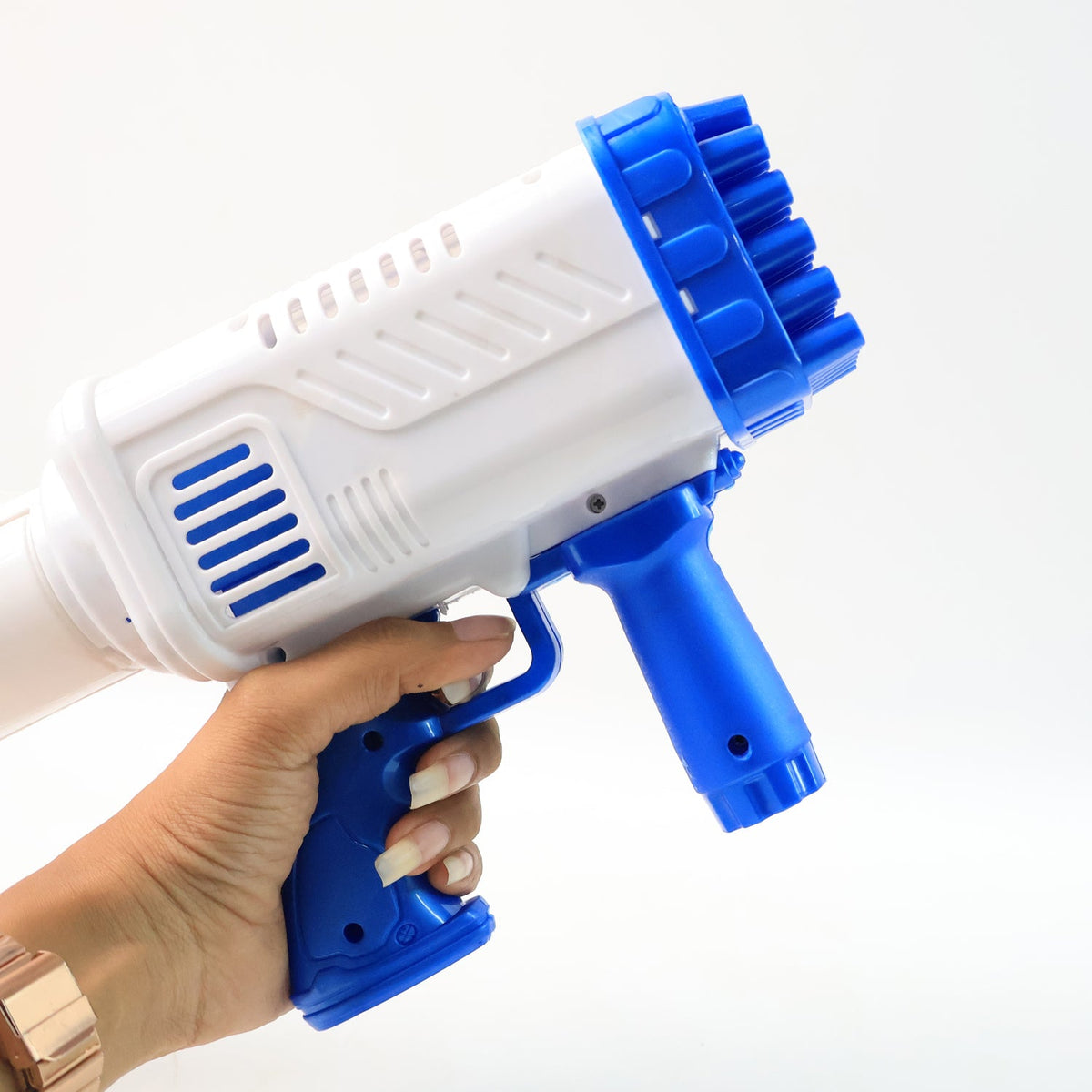 A hand with a rose gold watch holds a white and blue 32-hole bubble gun against a white background.
