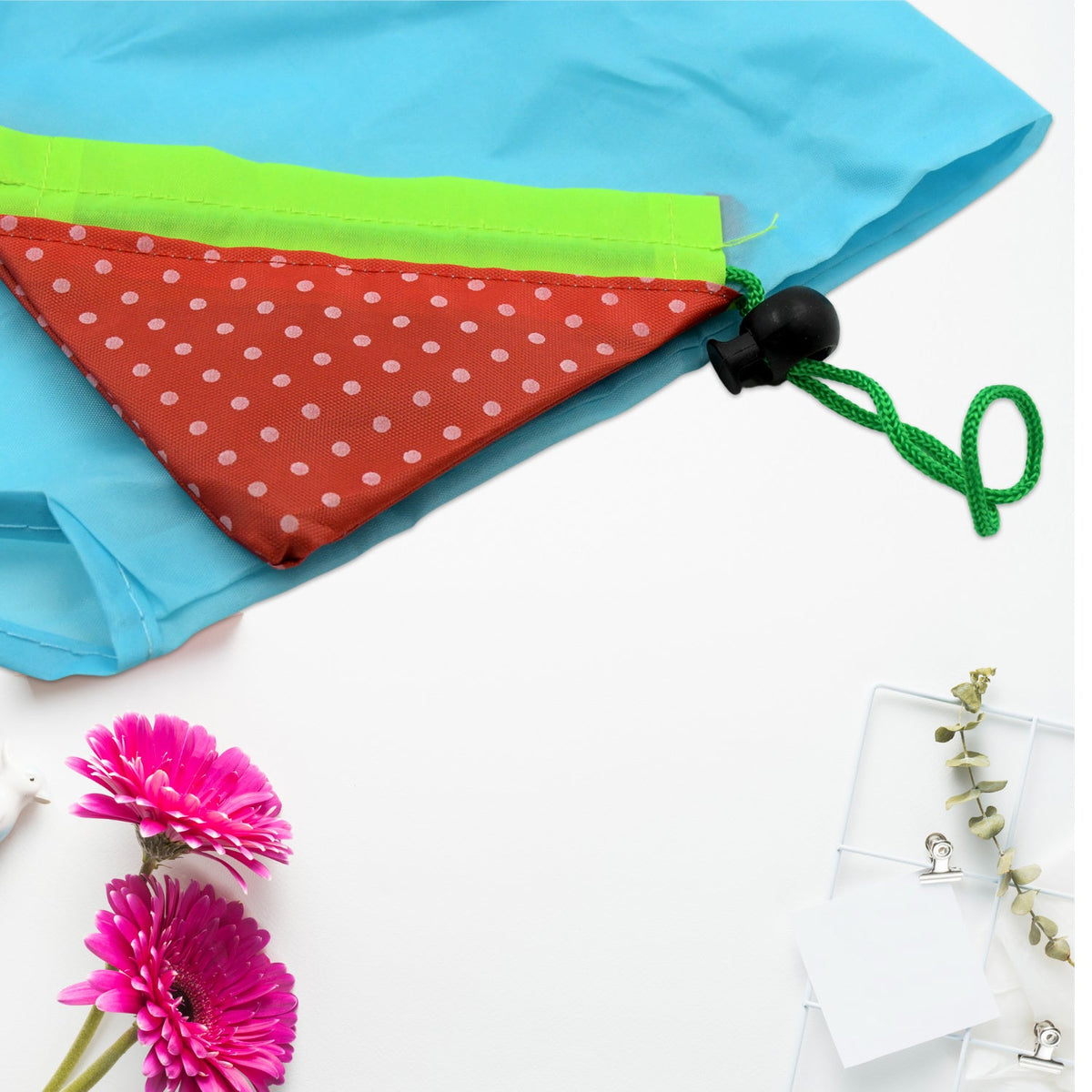Close-up of the red polka-dot and green pouch attached to a light blue reusable shopping bag.