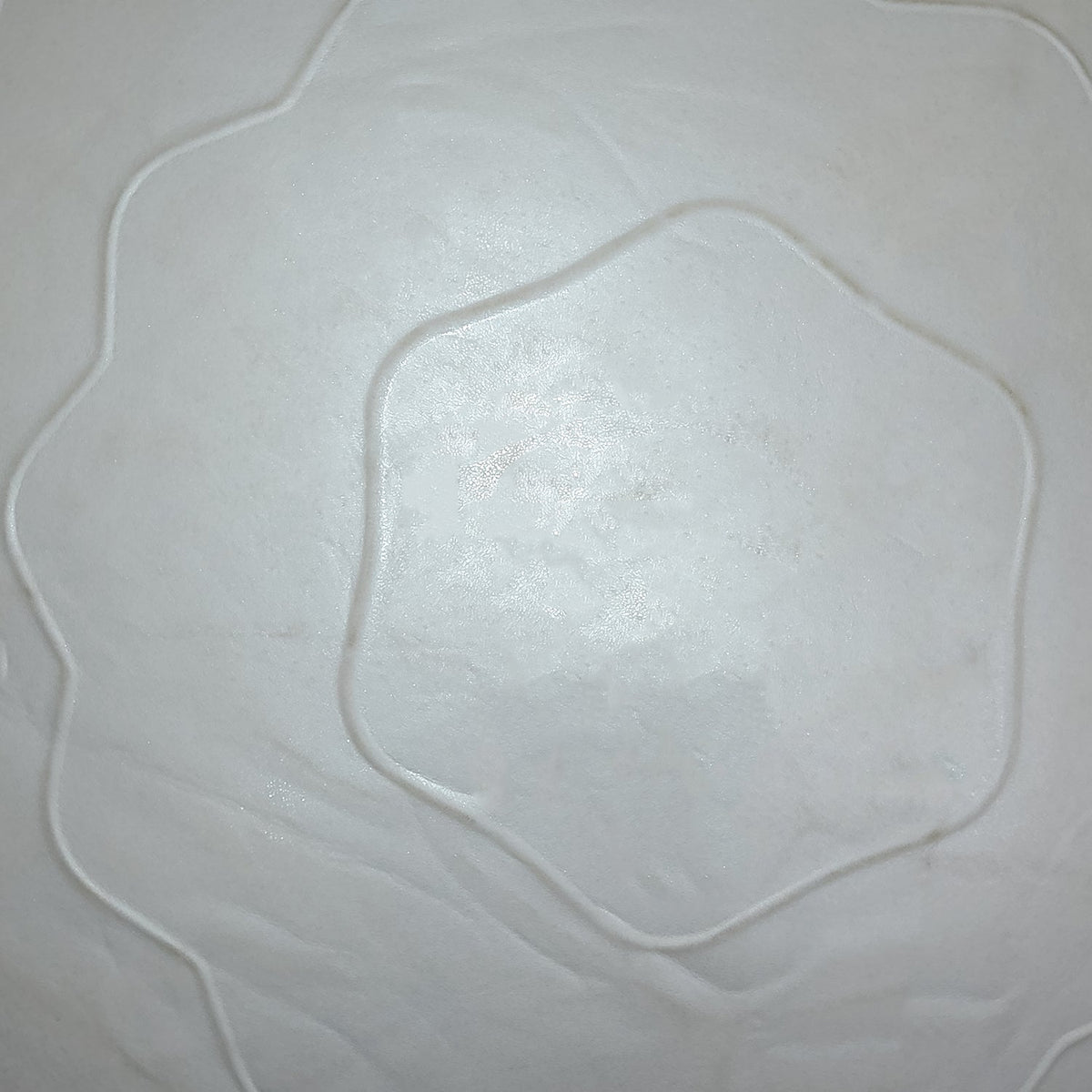 A very close-up, abstract view of the grey stability ball's wavy textured surface, showing a hexagonal pattern.