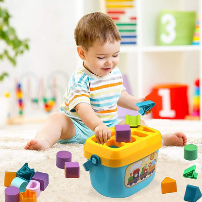 A baby plays with a blue and yellow shape sorter bucket, placing a purple block into a hole, surrounded by many other