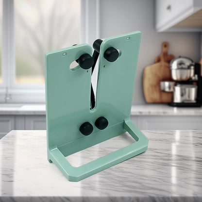 A mint green X-rod sharpener with black sharpening rods sits on a white marble kitchen counter.