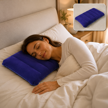 A woman with dark hair sleeps peacefully on a blue velvet inflatable pillow in a bed with white sheets.