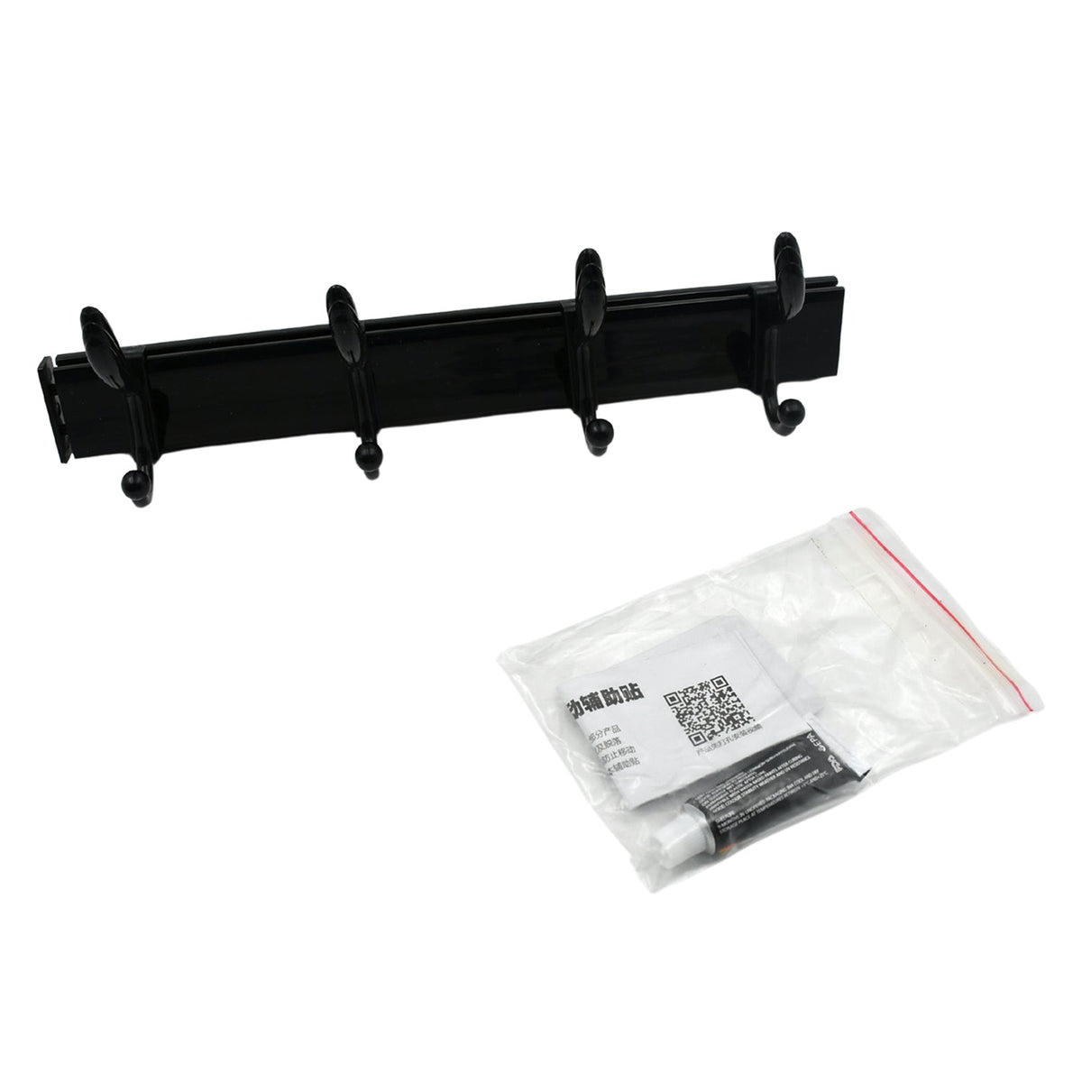 Black four-hook coat rack and a clear plastic bag containing adhesive and instructions on a white background.