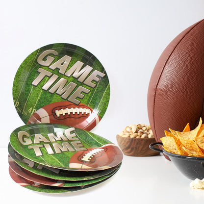 Arrangement of colorful round disposable paper plates with football and space themes on a party table.