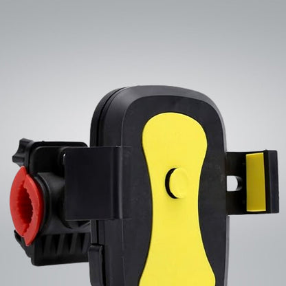 Close-up of the black and yellow phone mount with a red clamp, showing the central yellow button.