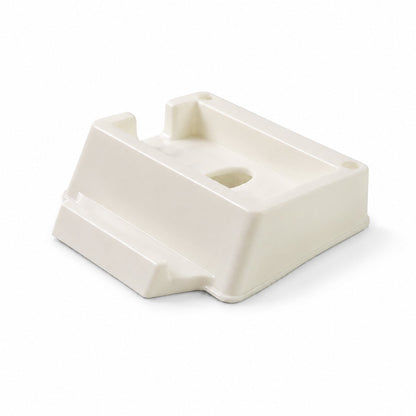 An angled view of the cream plastic phone stand reveals its sloped design and various openings.