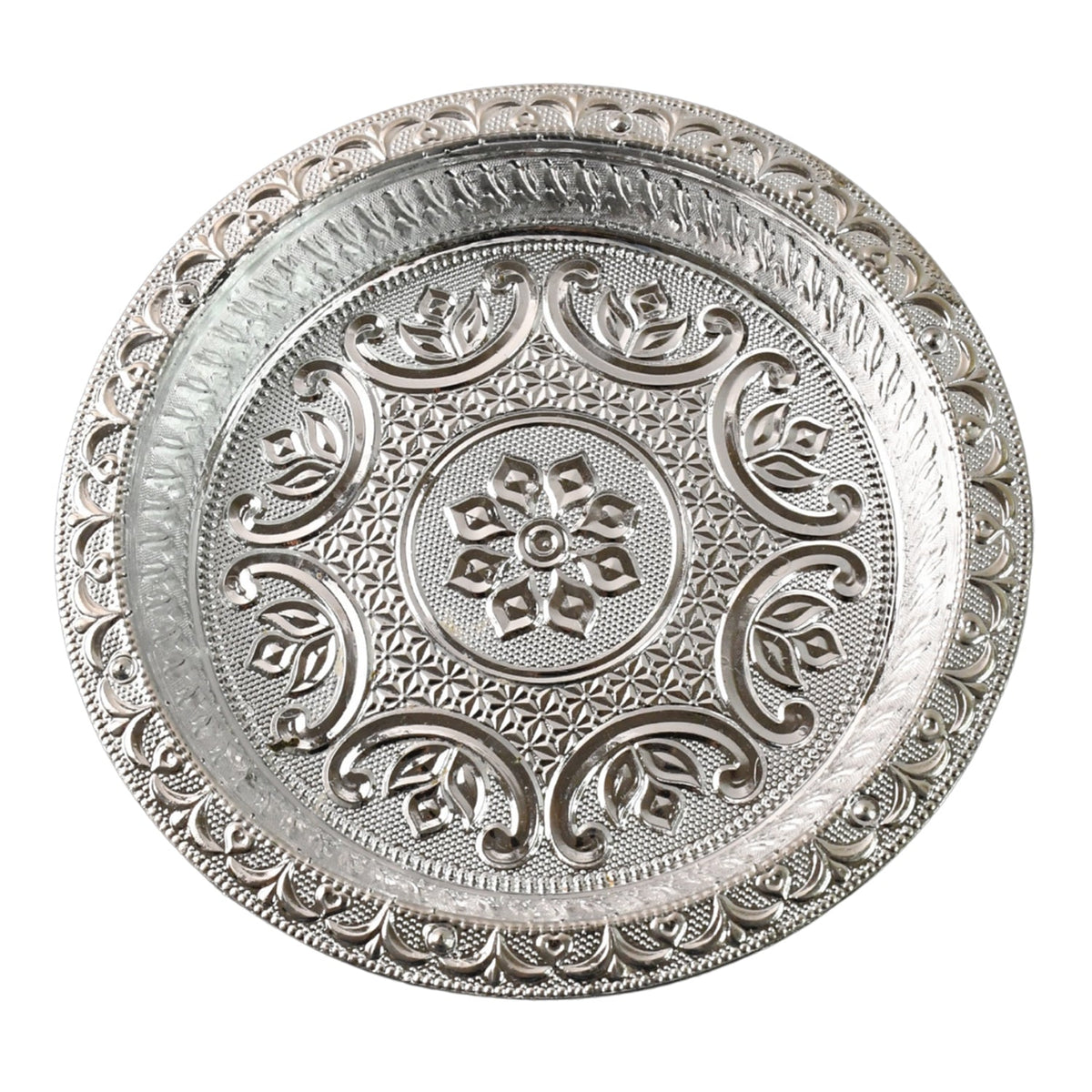A top-down view of a round silver-colored plastic pooja thali with detailed embossed floral and geometric patterns on a