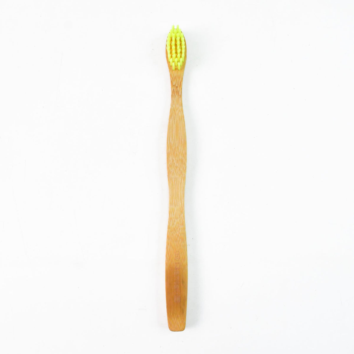 A single bamboo toothbrush with yellow bristles stands upright on a plain white background.