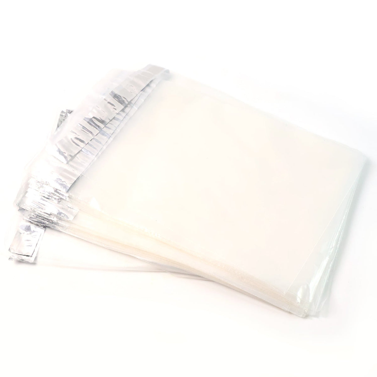 A stack of clear polybags with silver adhesive strips on a white background.