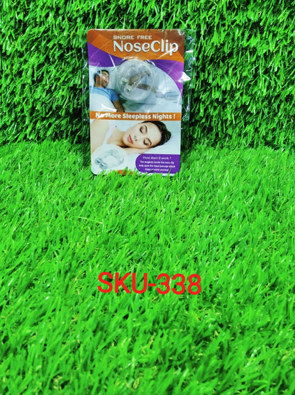 A packaged anti-snoring nose clip on a green artificial grass background with SKU-338 text.