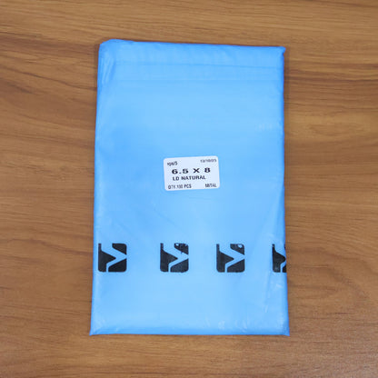 A light blue polybag with a white label showing size and quantity, and black logos at the bottom, on a wooden surface.