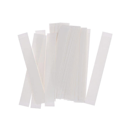 A pile of many thin, white, rectangular adhesive strips are scattered on a white background.