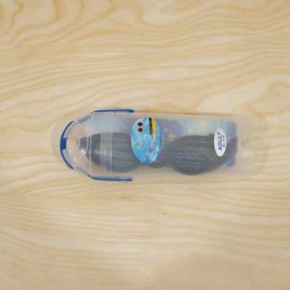 Black swimming goggles are stored in a clear plastic case with a blue lid on a light wooden surface.