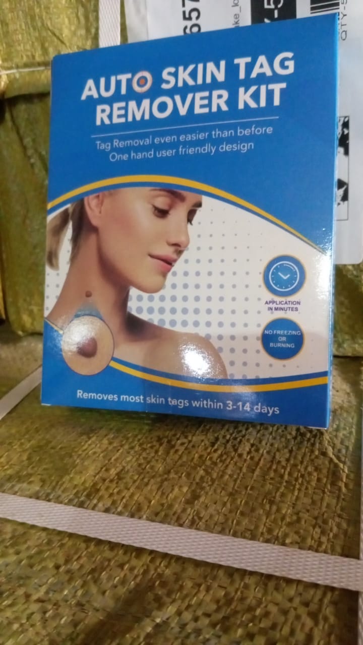 Blue box of the auto skin tag remover kit resting on a textured, possibly packaged, surface.