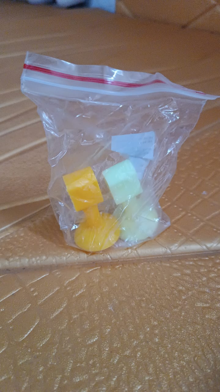 A clear plastic bag contains several colorful silicone suction cup door stoppers, including yellow, green, and white.