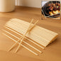 Natural bamboo skewers neatly arranged on a wooden surface.
