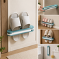 A teal and white folding shoe rack holds two pairs of white slippers on a light-colored door.
